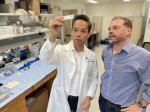Two men in conversation wearing lab coats.