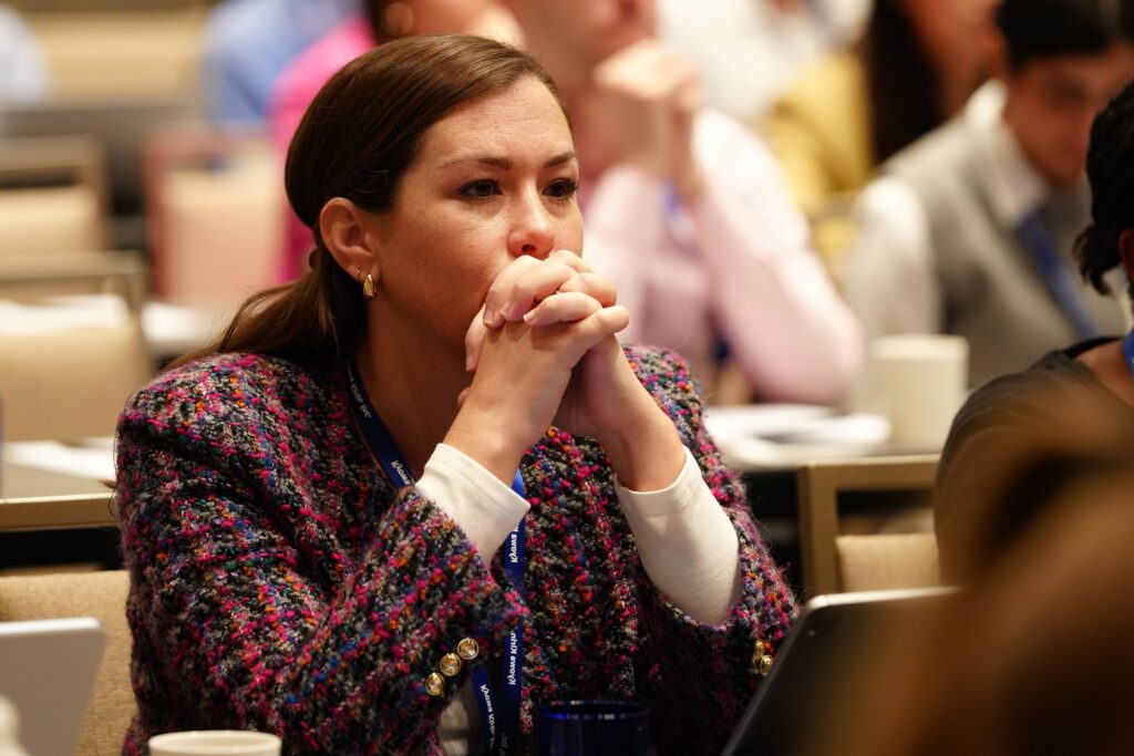 Photo of a woman with her hands clasped under her chin