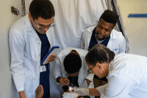 A group of Black students looking at diseased foot