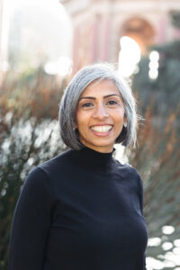 Photo of a woman with grey hair against a blurred urban background